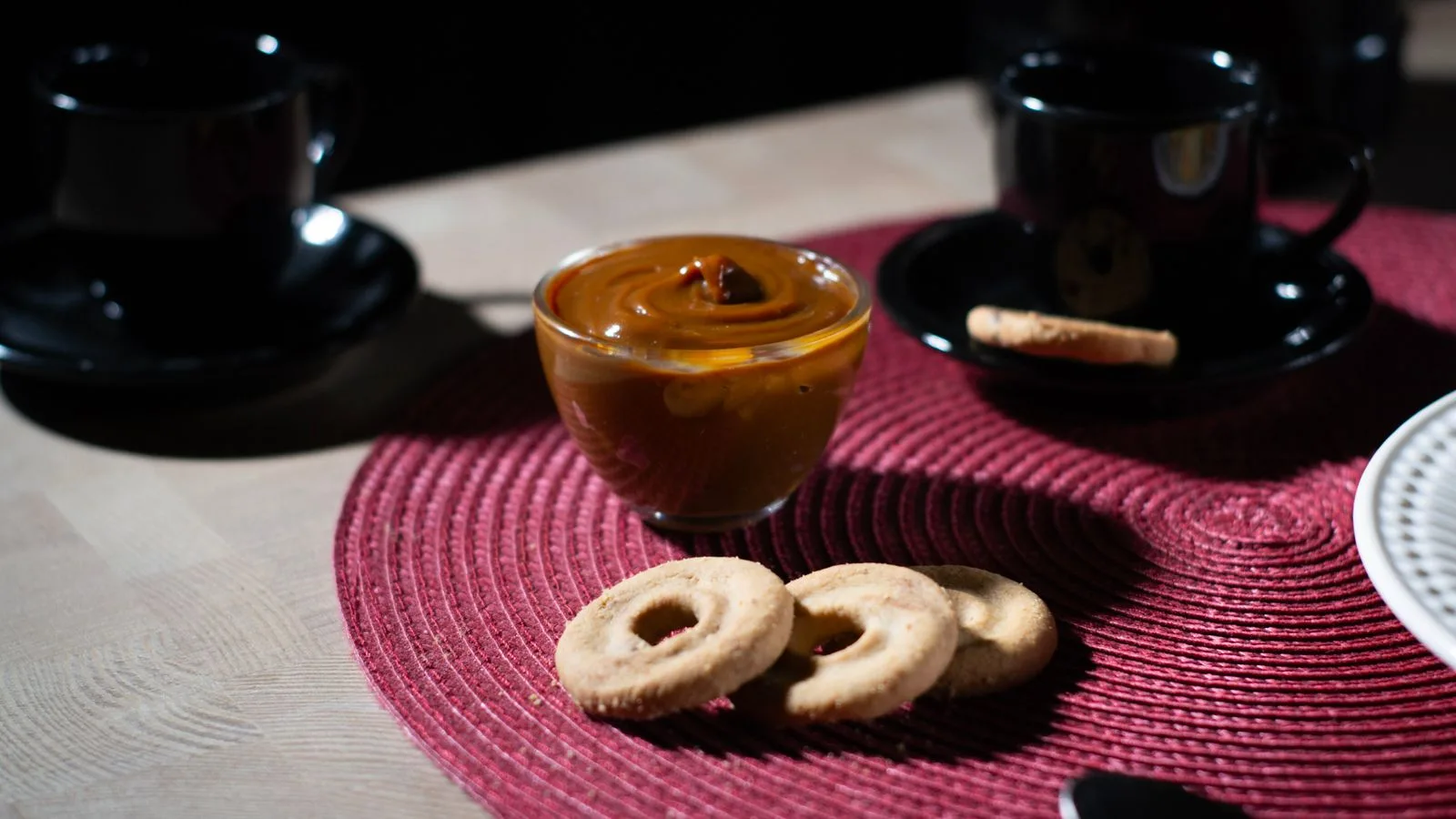 Enjoy a cozy coffee break with dulce de leche and cookies on a stylish setup in São Paulo.
