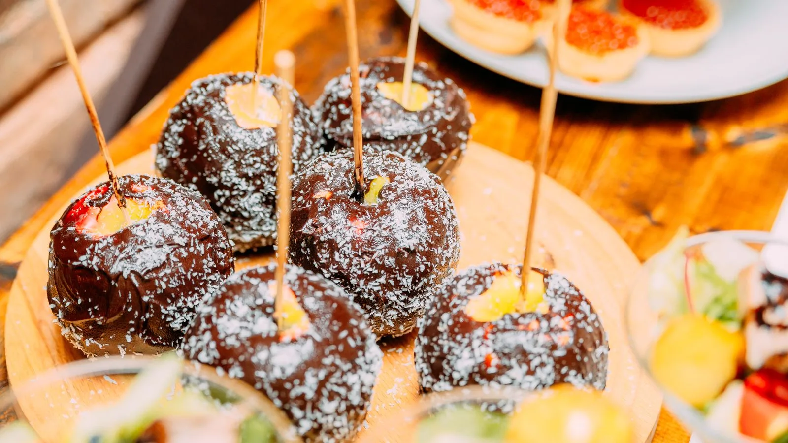 High angle of sweet apple in chocolate glaze sprinkled with coconut on banquet table