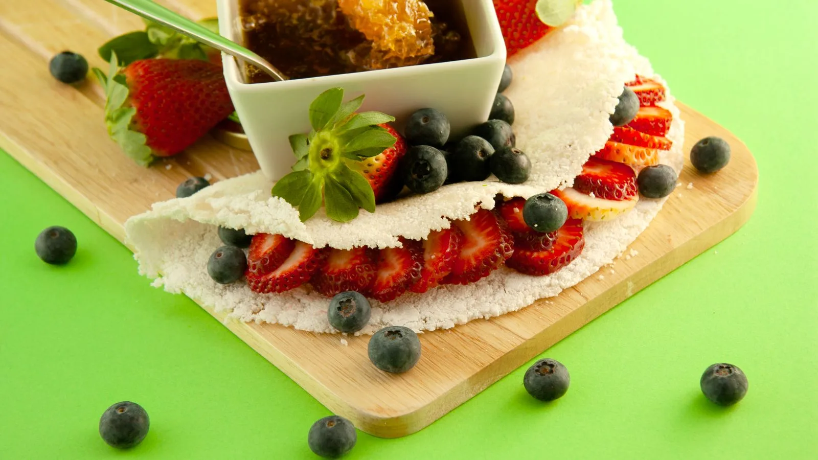 Tapioca wrap with strawberries, blueberries, and honeycomb makes a vibrant snack.