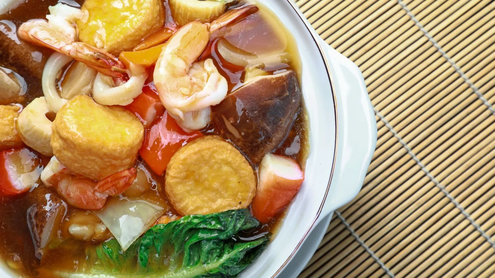 Vibrant seafood and vegetable hot pot with shrimp, tofu, and broth.