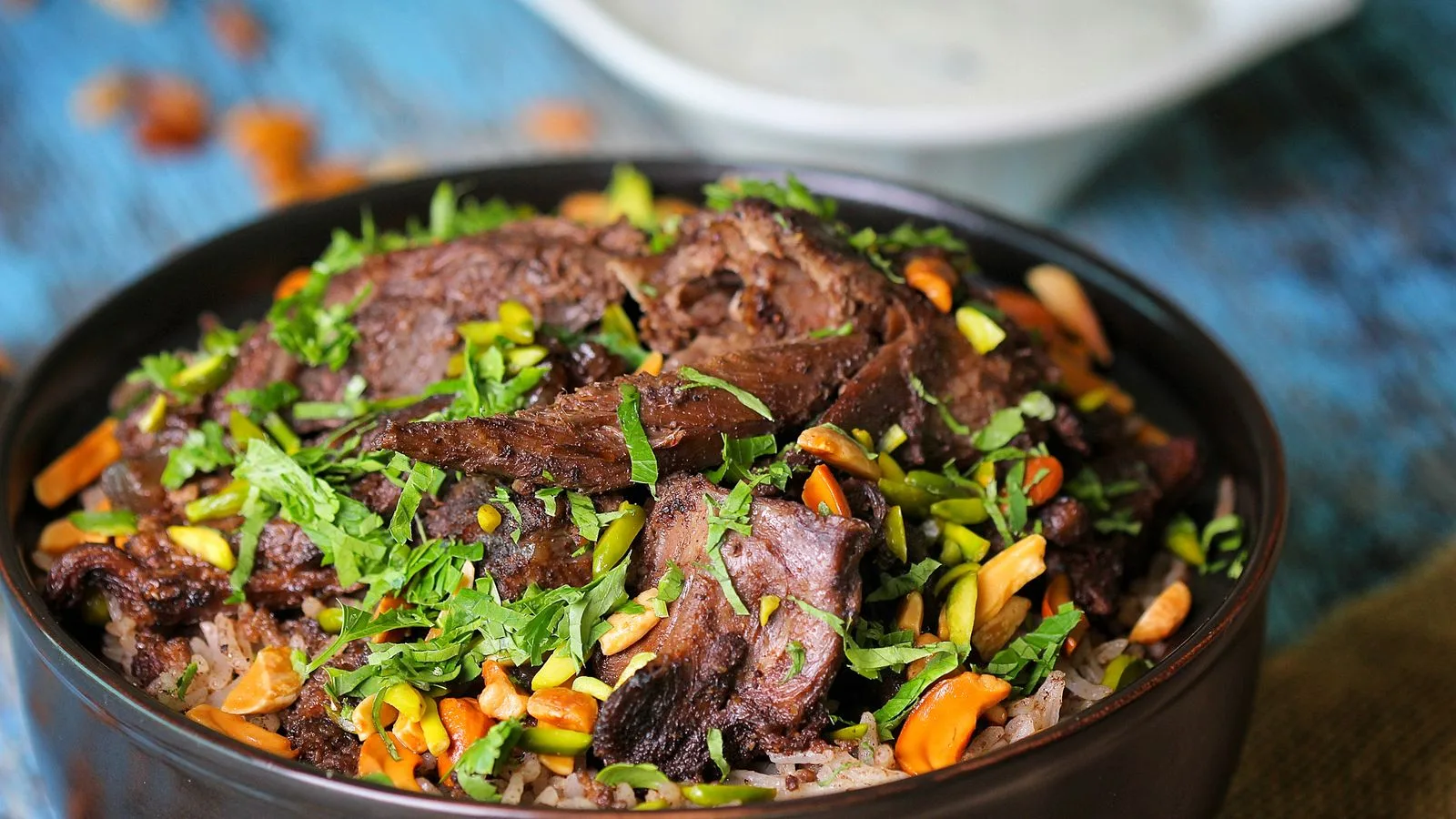 Close-up of flavorful lamb biryani garnished with herbs and nuts, highlighting its rich and vibrant colors.