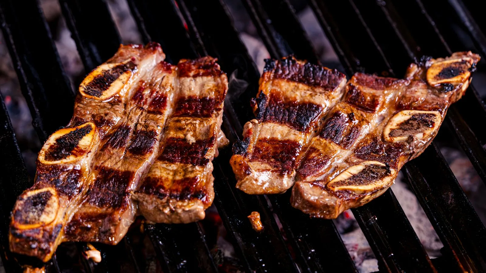 Close-up of juicy beef short ribs grilling over charcoal, with perfect sear marks and delicious aroma.