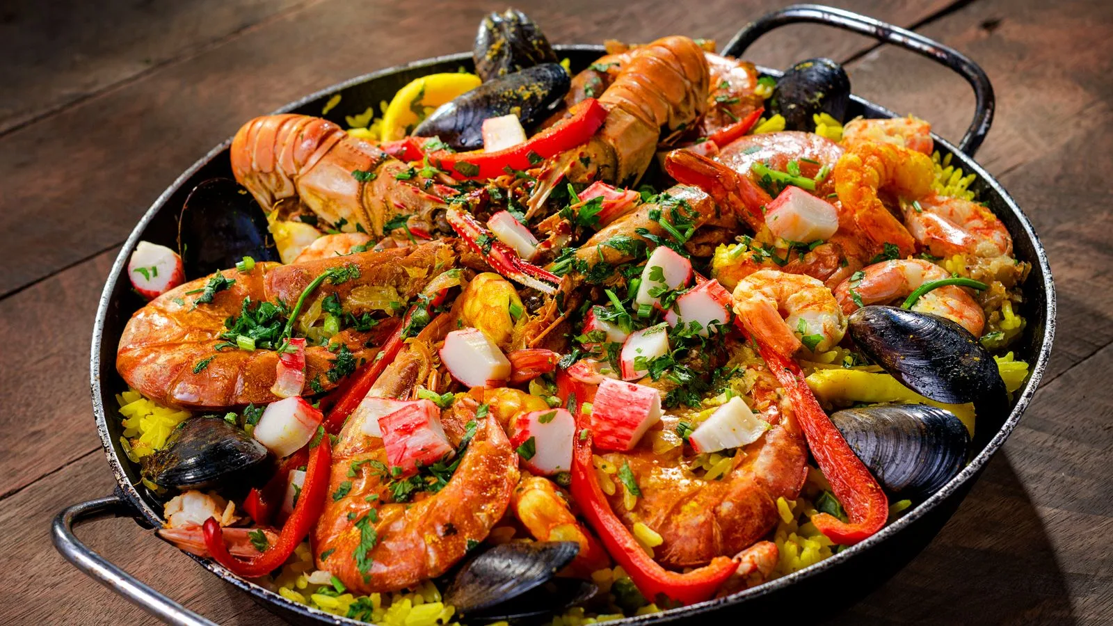 Colorful seafood paella with shrimp, mussels, and rice in a traditional pan.
