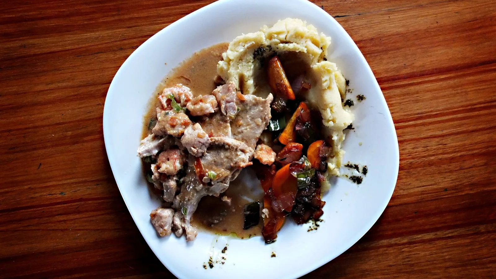 A comforting plate of Ecuadorian cuisine featuring mashed potatoes and savory beef stew.