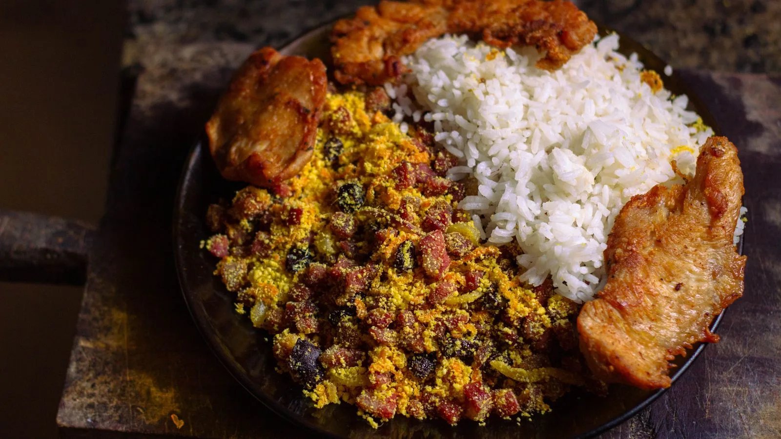 Authentic Brazilian dish with rice, bean mixture, and fried chicken pieces.