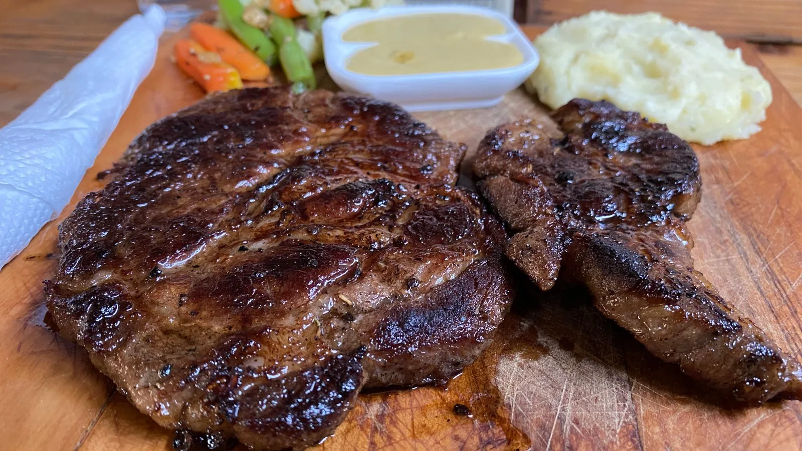 Juicy grilled steak served with creamy mashed potatoes and a side of sautéed vegetables.
