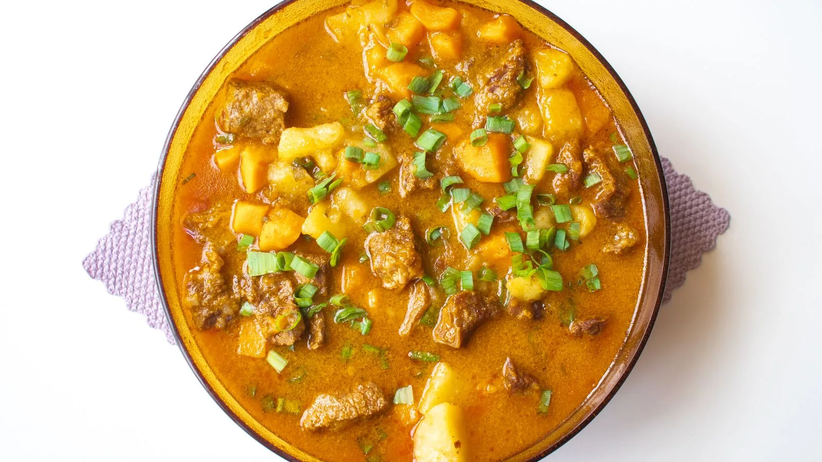 Delicious Brazilian beef stew with potatoes and green onions served in a bowl.