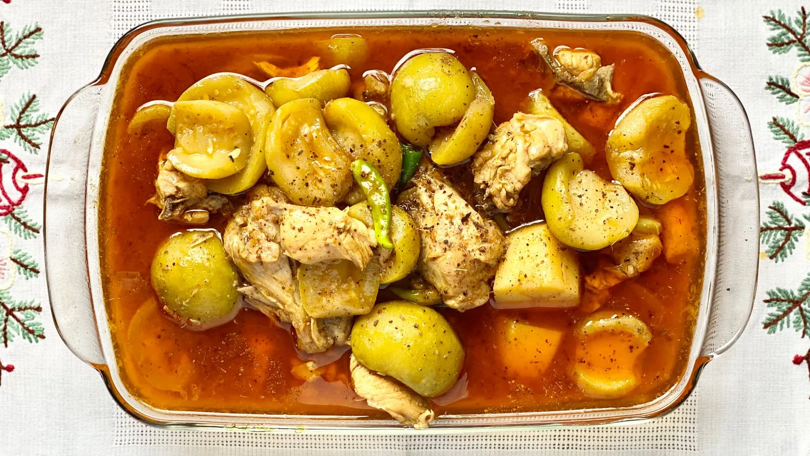 Top view of a hearty chicken and vegetable stew in a glass dish.