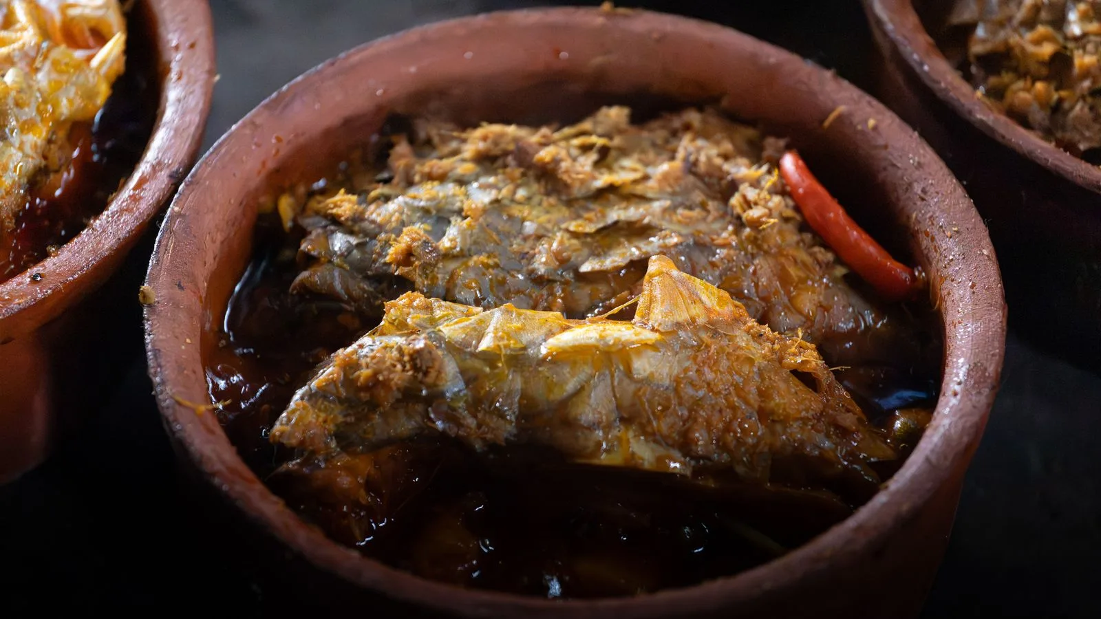 Authentic Vietnamese clay pot fish with spices, showcasing Đông Dương culinary traditions.