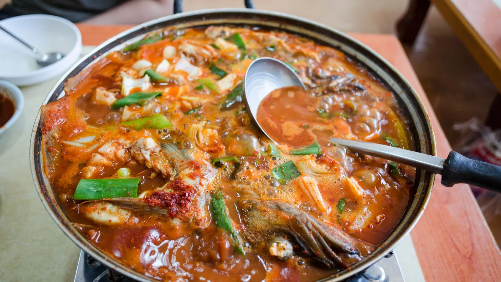 Delicious seafood stew simmering in a wok with fresh vegetables. Perfect for food lovers.