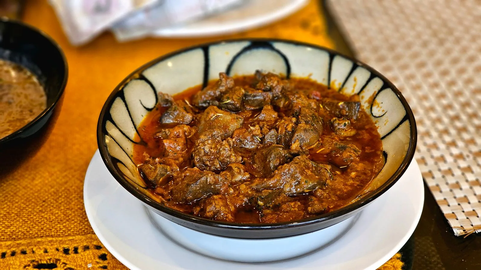 Rich and flavorful lamb curry served in a decorative bowl. Perfect for culinary enthusiasts.