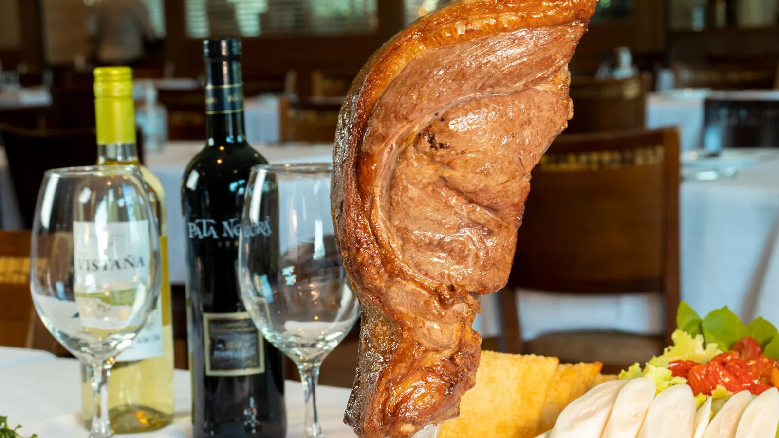 Succulent grilled picanha served with wine and salad in a cozy São Paulo restaurant for a delicious dining experience.