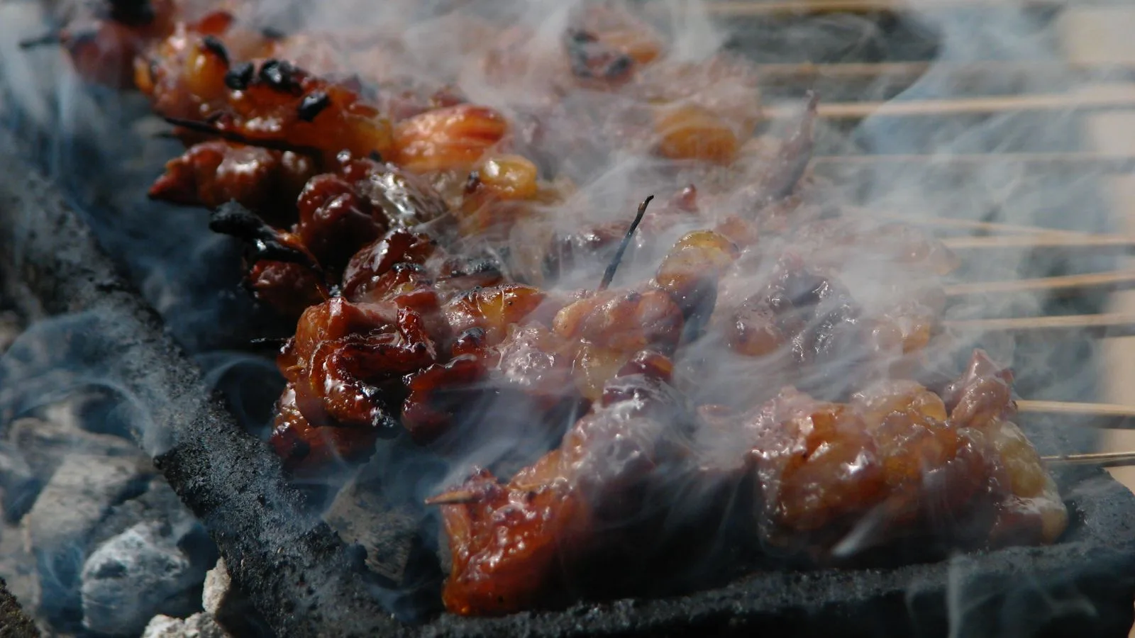 Close-up of delicious grilled meat skewers with a smoky aroma.