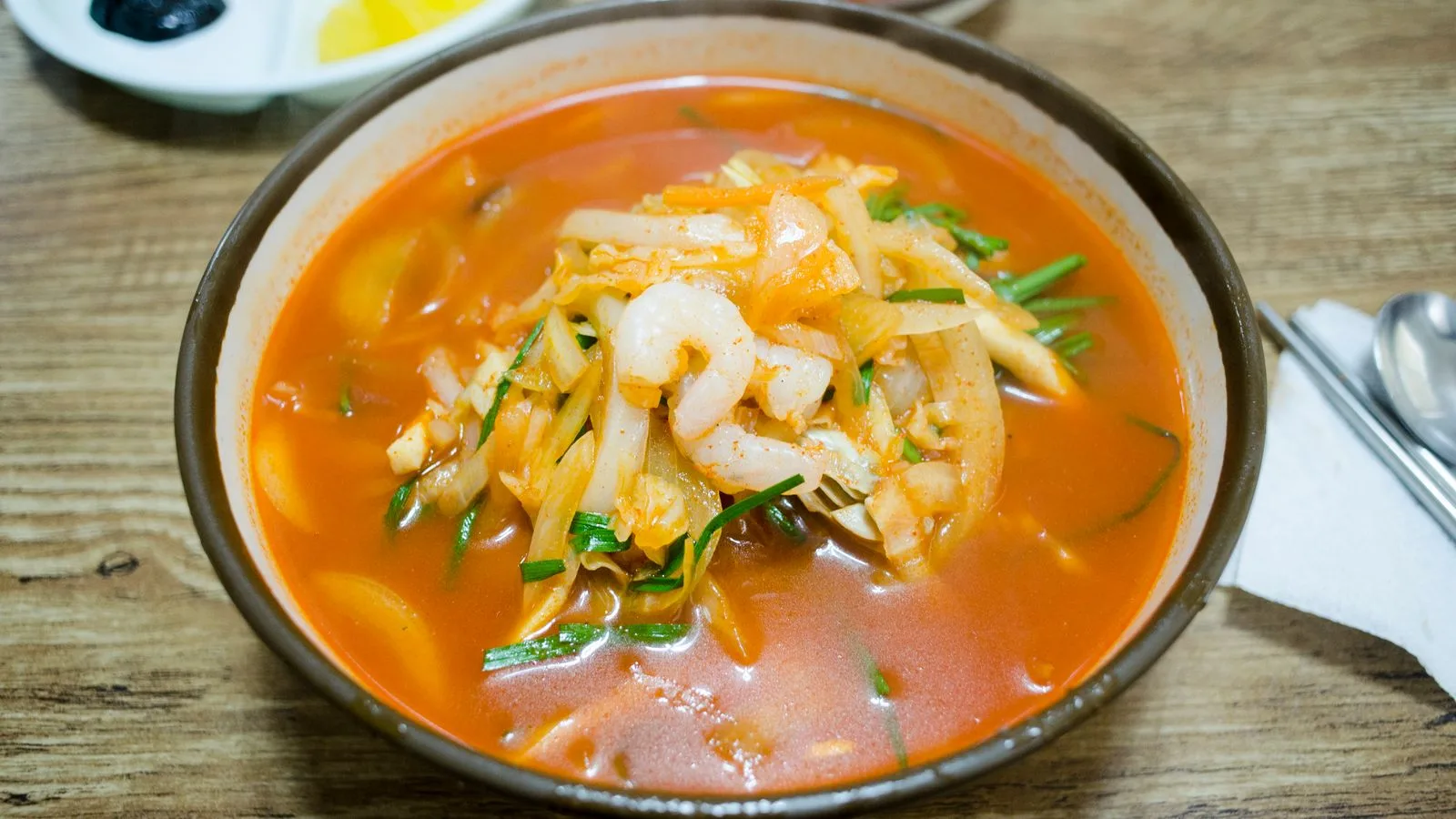 Delicious shrimp soup with vegetables in a ceramic bowl, perfect for food photography.